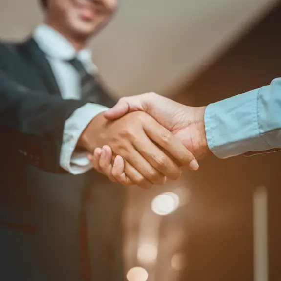 2 gentlemen shaking hands to close a marketing deal.