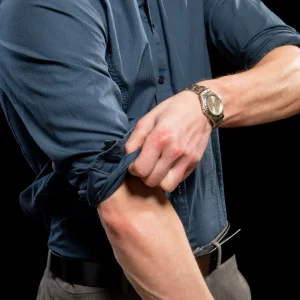 Man rolling up his shirt sleeves.